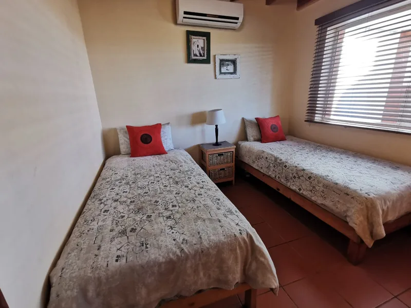 Downstairs twin bedroom with red linen accents