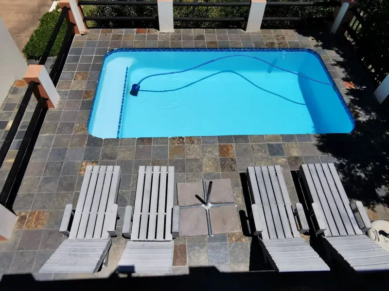 High-angle view of pool deck with 4 loungers