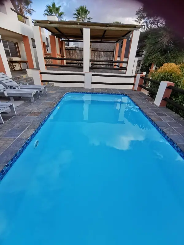 Pergola shaded lounge area beside the pool